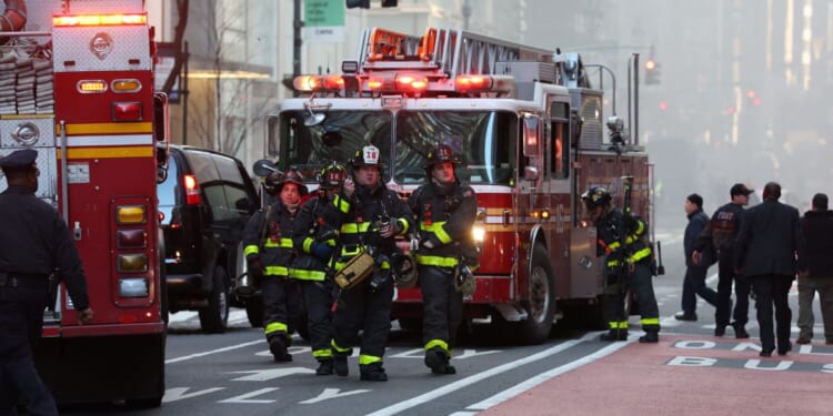 Firefighters from the New York City Fire Department workout the scene of the fire amidst heavy smoke in Midtown Manhattan on March 17, 2026.
