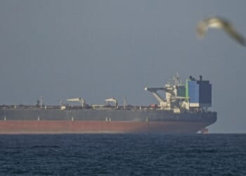 A ship waits to travel through the Strait of Hormuz in Oman on April 8, 2026.