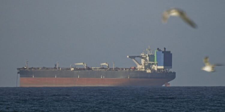 A ship waits to travel through the Strait of Hormuz in Oman on April 8, 2026.