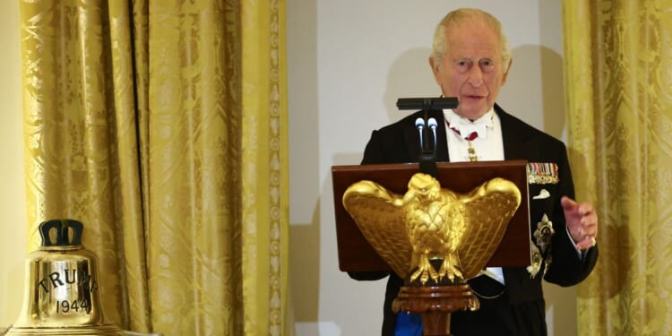King Charles III speaks beside the original bell from the H.M.S. Trump, a World War II-era submarine and inscribed "Trump 1944," a gift to President Donald Trump during a State Dinner in the East Room of the White House in Washington, D.C., on April 28, 2026.
