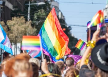 A picture of a crowd holding up LGBT flags during a gay pride parade.
