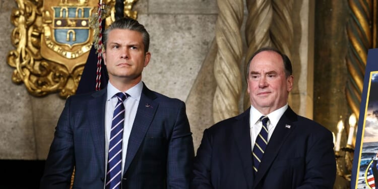 Secretary of War Pete Hegseth and Secretary of the Navy John Phelan stand together as President Donald Trump announced the creation of the “Trump-class” battleship during a statement to the media at Trump’s Mar-a-Lago estate on Dec. 22, 2025, in Palm Beach, Florida.