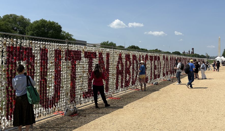 The memorial wall remembers the thousands of Ukrainian children who have been taken from the Eastern European nation amid the country's ongoing war with Russia. (Matt Delaney/The Washington Times)
