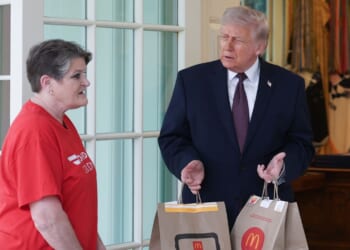 President Donald Trump receives a DoorDash delivery of McDonald's from Sharon Simmons before he speaks to the press during an event outside the Oval Office of the White House on April 13, 2026, in Washington, D.C.