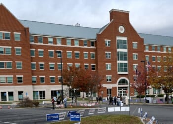 Students, parents, and others hold signs outside the Loudoun County school board meeting on Oct. 26, 2021, in Ashburn, Virginia.