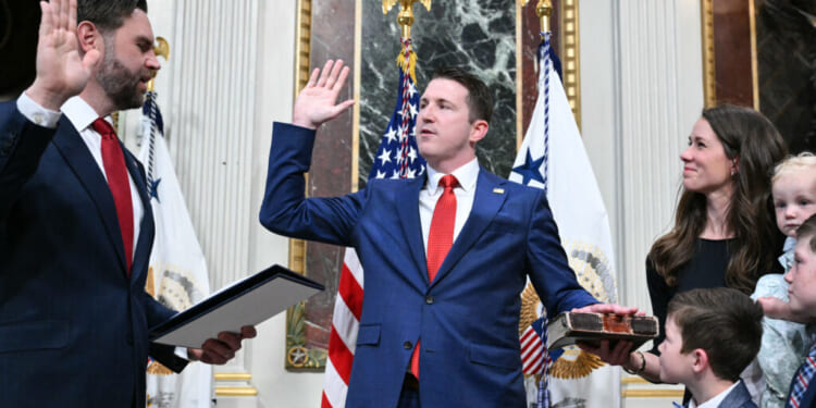 (L/R) US Vice President JD Vance swears in Colin McDonald as Assistant Attorney General for the National Fraud Enforcement Division as McDonald's wife Janessa holds the Bible in the Eisenhower Executive Office Building, next to the White House in Washington, DC on April 1, 2026. McDonald will be the first Assistant Attorney General for the Department of Justice's newly created National Fraud Enforcement Division. (Photo by Mandel NGAN / AFP via Getty Images)