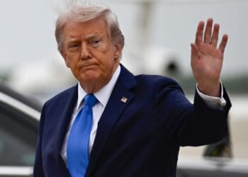 President Donald Trump waves after stepping off Air Force One at Joint Base Andrews upon returning from Florida Saturday.