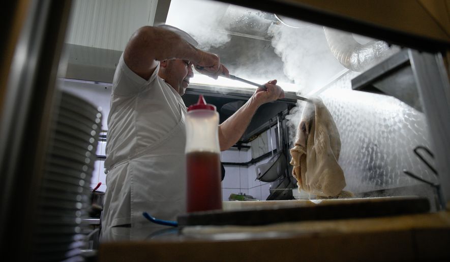 A man cooks traditional tripe soup, known as "iskembe" in Turkish and "patsas" in Greek, in a restaurant in Istanbul, Turkey, Friday, March 27, 2026. (AP Photo/Emrah Gurel)