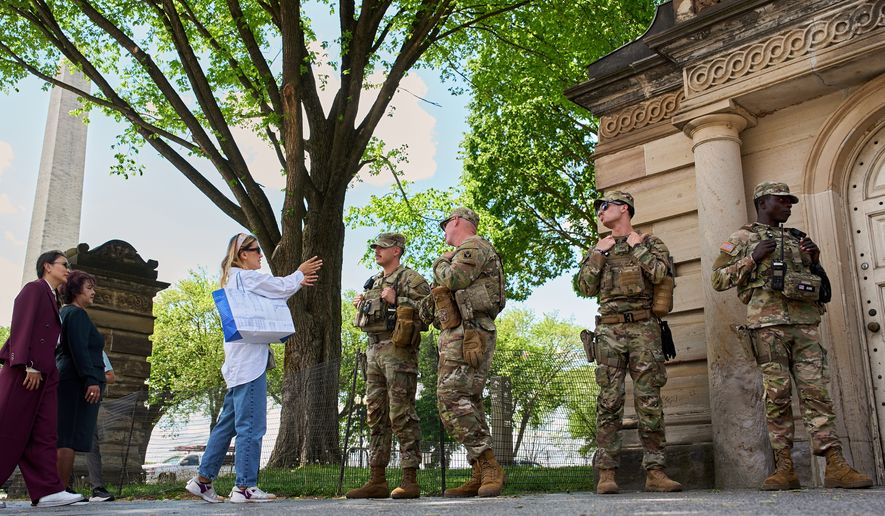 A touris ask members of the Florida National Guard for directions on the National Mall, across from the Washington Monument, Friday April 17, 2026, in Washington. (AP Photo/Jacquelyn Martin)