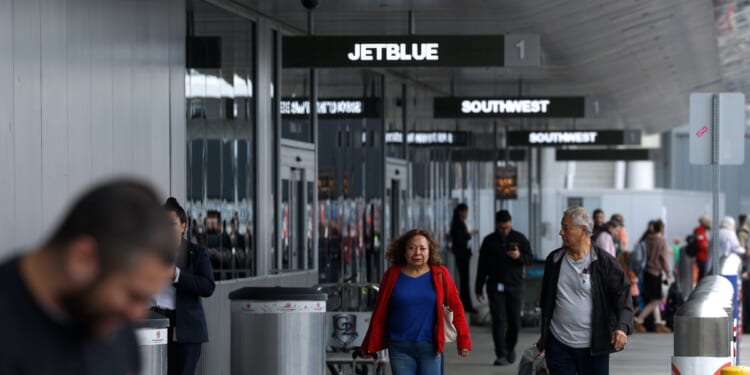 Travelers walk with their bags at Los Angeles International Airport on March 31, 2026, in Los Angeles, California.