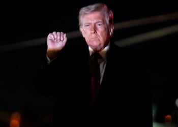 President Donald Trump holds up a fist as he exits Air Force One at Joint Air Base Andrews, Maryland, on March 29, 2026.