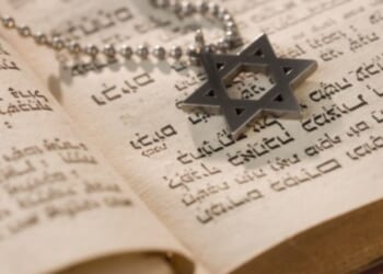 A Star of David medallion sits on a Torah.