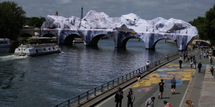 Artist JR, the ‘French Banksy,’ creates a ‘cave’ installation over Paris’ oldest bridge