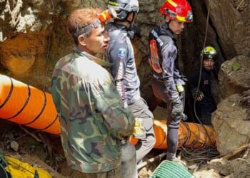 Rescuers race to reach 7 trapped in a Laos cave after flash floods block exit