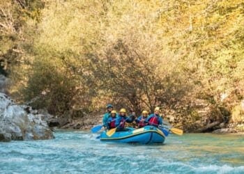 A young family with a mother guiding her three kids on a rafting expedition.