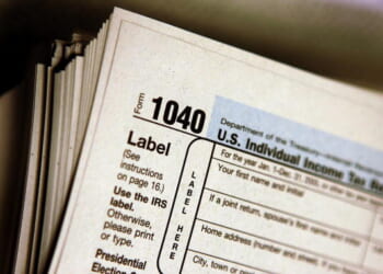 An individual income tax 1040 Form sits on a stack of varying tax documents on March 23, 2006.