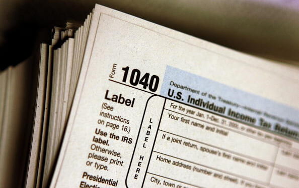 An individual income tax 1040 Form sits on a stack of varying tax documents on March 23, 2006.