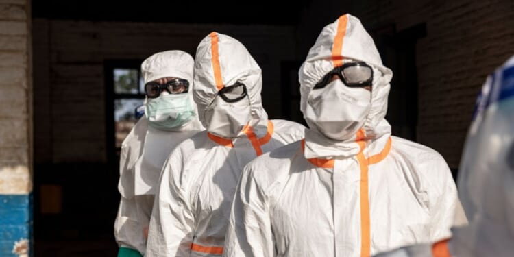 Workers line up to disinfect their protective equipment at General Referral Hospital of Mongbwalu during the Ebola outbreak response in Mongbwalu, Ituri province, eastern Democratic Republic of Congo, on May 20, 2026.