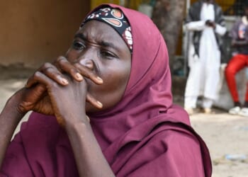A family member of a victim of the Islamist terror group Boko Haram clasps her hands together in Babban Gide on Sept. 4, 2024.