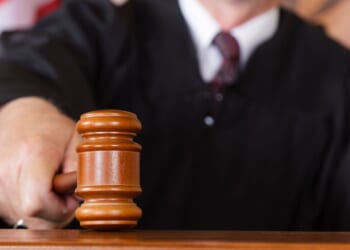 A close-up image of a judge holding a gavel.