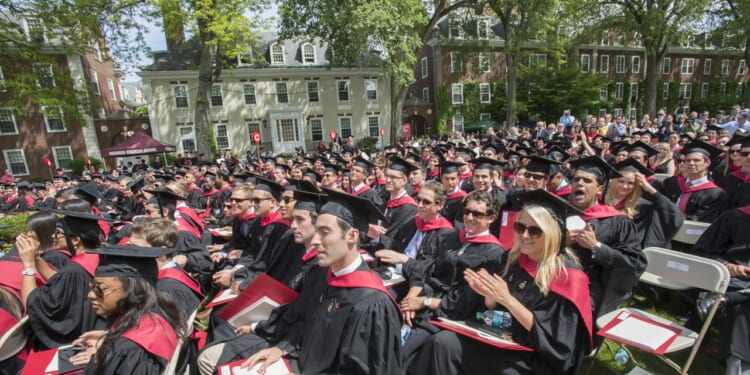 Harvard Business School graduates seated outdoors
