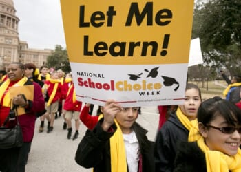 Child protester holding a sign that says "Let me learn! National School Choice Week"