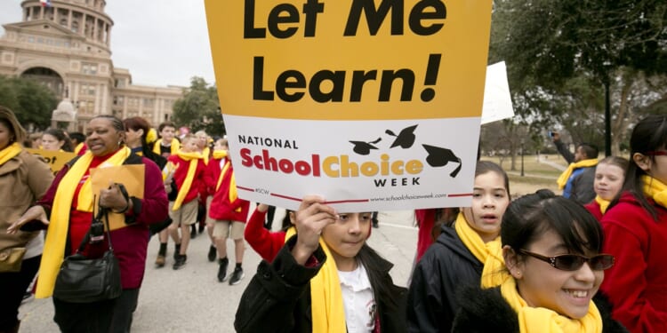 Child protester holding a sign that says "Let me learn! National School Choice Week"