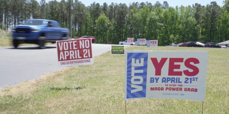 A truck passes political signs outside a polling place at Good Shepherd Catholic Church in South Hill, Virginia, on April 21, 2026.