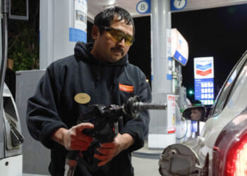 A man using a gas pump.