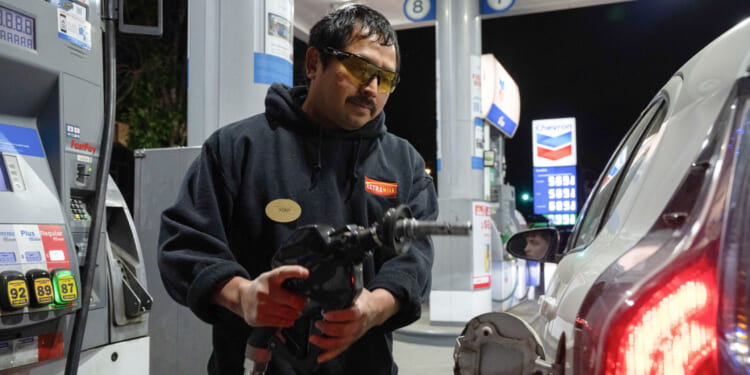 A man using a gas pump.