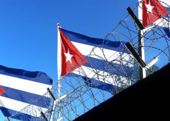 The Cuban flag flies above the walls of a prison.