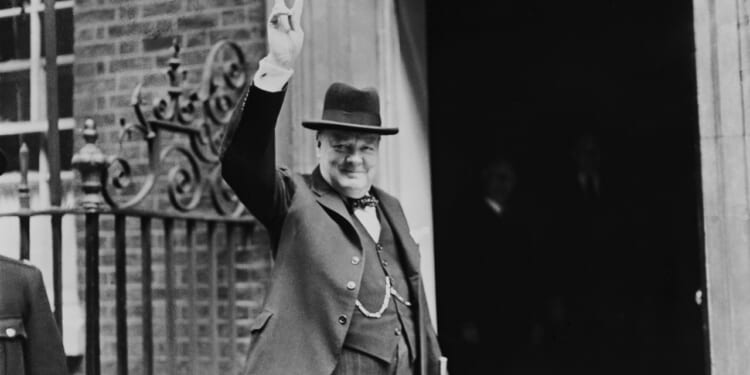 Winston Churchill holding up his hand in a "V" sign