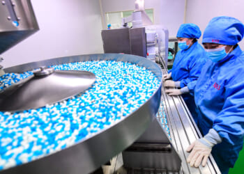 Employees work on the production line of Xiaoqinglong capsules, a cough medicine, at a factory on January 12, 2023 in Shenyang, Liaoning Province of China.