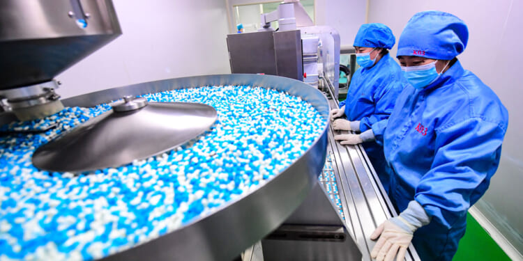 Employees work on the production line of Xiaoqinglong capsules, a cough medicine, at a factory on January 12, 2023 in Shenyang, Liaoning Province of China.