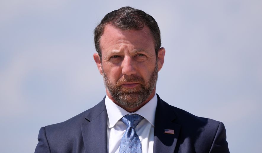 Homeland Security Secretary Markwayne Mullin, listens as President Donald Trump speaks to the press after returning and stepping off Air Force One, Wednesday, May 20, 2026, at Joint Base Andrews, Md. (AP Photo/Jacquelyn Martin)