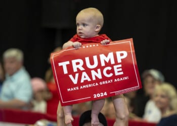 A baby holding a Trump Vance sign