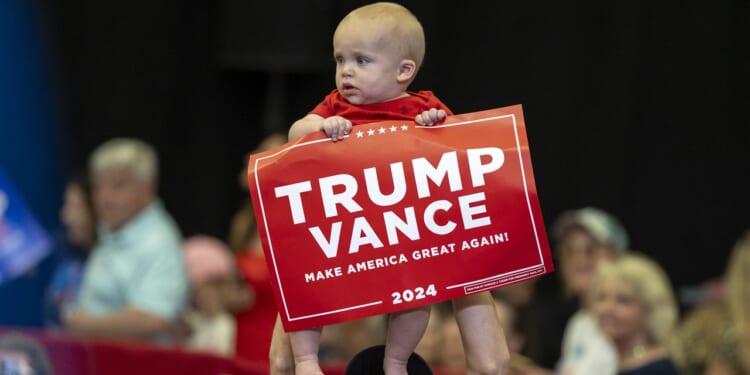 A baby holding a Trump Vance sign