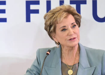 Linda McMahon looks on.