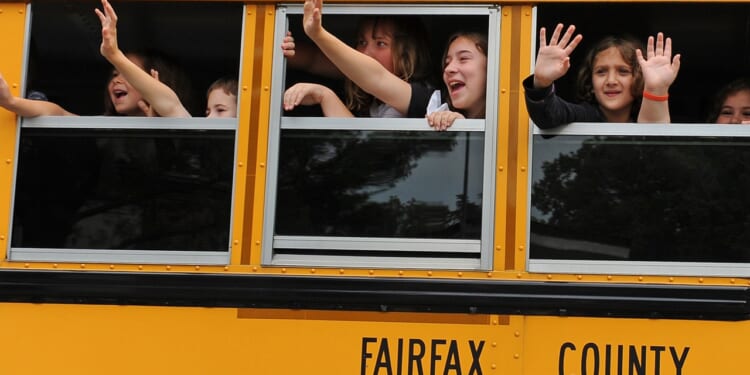 Students waving from a bus that says "Fairfax County"