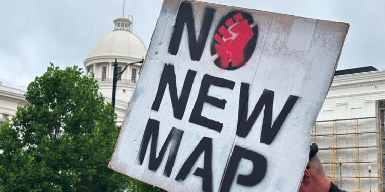 A demonstrator holds up a sign outside the Alabama Statehouse in Montgomery, Alabama, on May 7, 2026.
