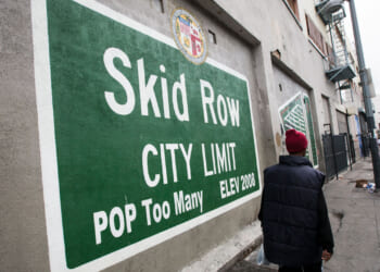 Green sign with white lettering reading "Skid Row City Limit. Pop Too Many."