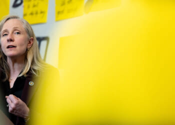 Abigail Spanberger framed by an out-of-focus yellow sign in the foreground.