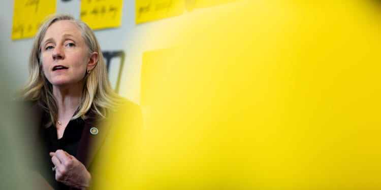 Abigail Spanberger framed by an out-of-focus yellow sign in the foreground.
