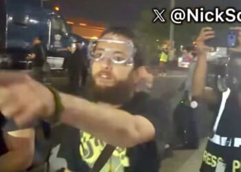 A foul-mouthed protester screams death threats against a law officer's family in video posted to social media Thursday.