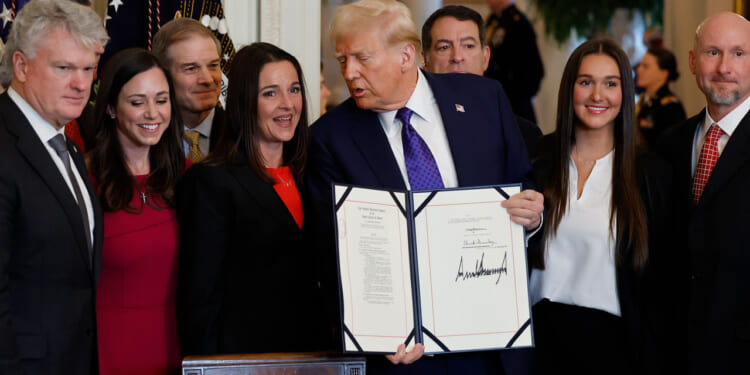 Mike Collins (L), President Donald Trump and the family of Laken Riley.