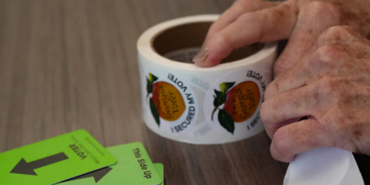A woman tears stickers on Election Day.