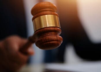 Man slams gavel on a wooden block.