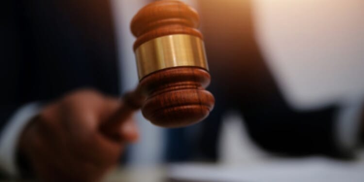 Man slams gavel on a wooden block.