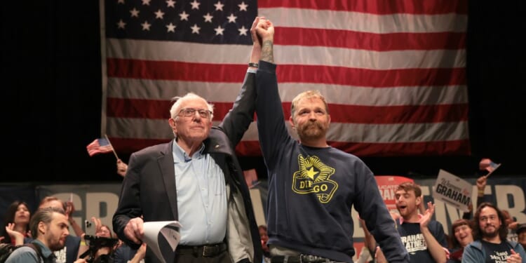 Sen. Bernie Sanders and Democratic U.S. Senate candidate Graham Platner stand together during a “Fighting Oligarchy” tour stop at the Collins Center for the Arts on the University of Maine campus on May 24, 2026, in Orono, Maine.