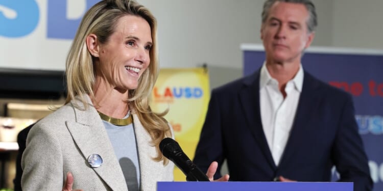 Governor Gavin Newsom looks on as his wife Jennifer Siebel Newsom speaks.
